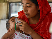 

A mother is holding an oxygen mask on the face of her child, who is suffering from respiratory distress, as seen in front of the emergency...