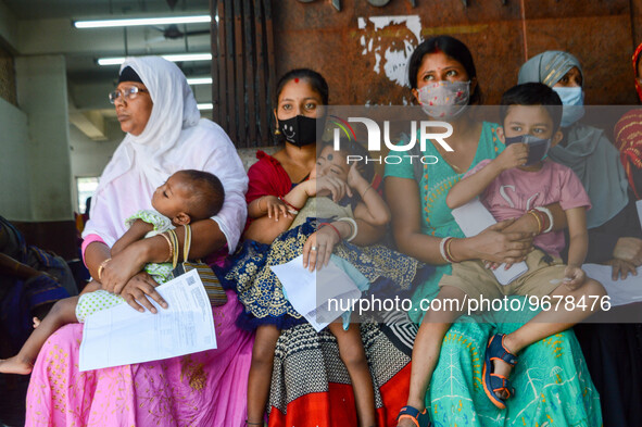 

Mothers are seen waiting with their children in front of a fever clinic at a government-run children's hospital in Kolkata, India, on Marc...