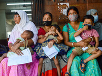 

Mothers are seen waiting with their children in front of a fever clinic at a government-run children's hospital in Kolkata, India, on Marc...