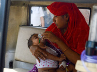 

A mother is holding an oxygen mask on the face of her child, who is suffering from respiratory distress, as seen in front of the emergency...