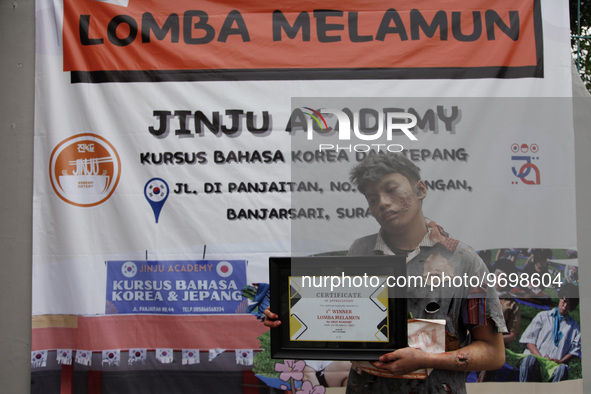 Aldo (17), posing for a photograph holding a champion's certificate after winning a daydream competition which was held in Solo, Central Jav...