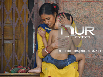 A woman comforts her six-year-old daughter, who is suffering from fever, at a hospital in Kolkata on March 06, 2023. The eastern Indian stat...