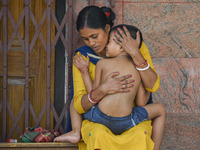 A woman comforts her six-year-old daughter, who is suffering from fever, at a hospital in Kolkata on March 06, 2023. The eastern Indian stat...