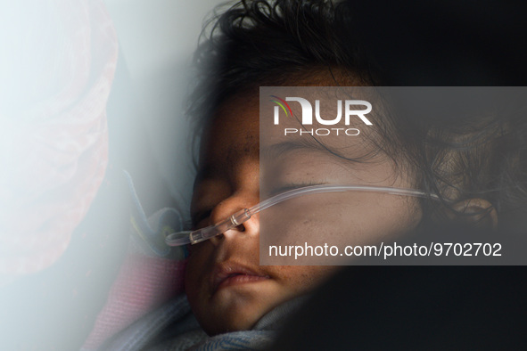 A five-month-old child, who is suffering from respiratory problems, is seen, inside an ambulance, at a hospital in Kolkata on March 06, 2023...