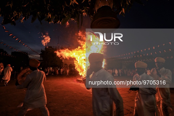 People performs rituals during 'Holika Dahan', at City Palace in Jaipur, Rajasthan,India, Monday, March 6, 2023. 