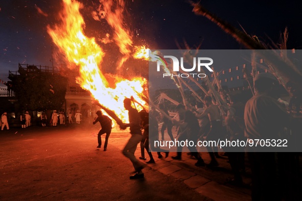 People performs rituals during 'Holika Dahan', at City Palace in Jaipur, Rajasthan,India, Monday, March 6, 2023. 