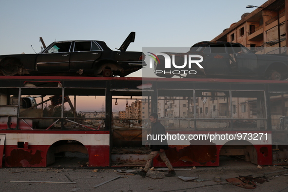 Boy little walk at the street in the northern Syrian city of Aleppo on December 24, 2015. The Syrians used the wreckage buses, cars and conc...