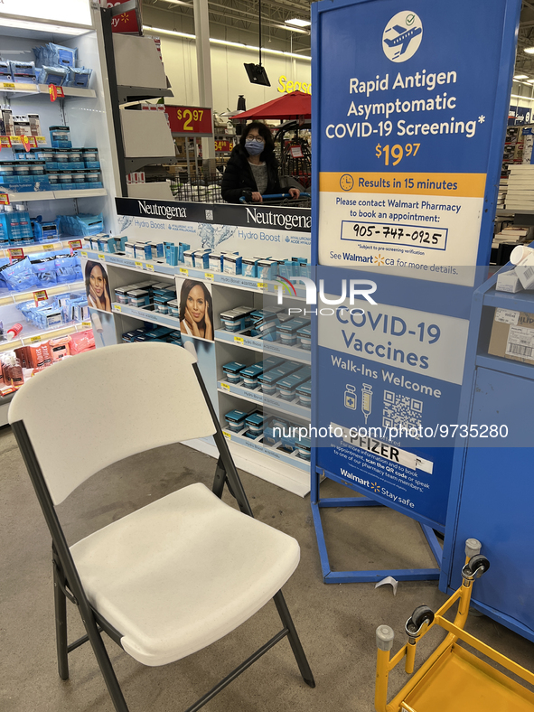 Sign at a Walmart store informing customers that they can get their COVID-19 vaccine or a COVID-19 antigen test  in Toronto, Ontario, Canada...