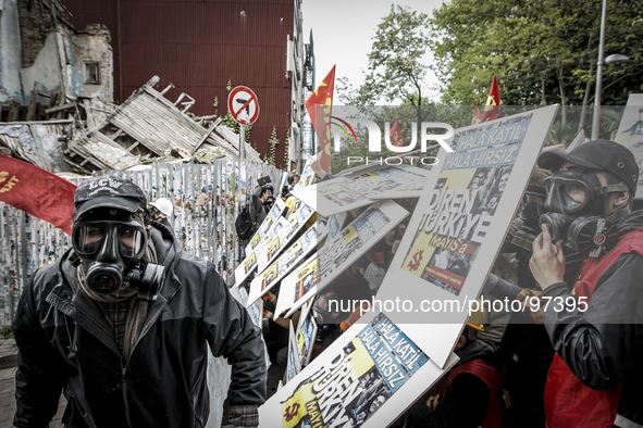 A Riot police officer leads a detained leftist demonstrator during clashes in downtown Istanbul, Turkey, Thursday, May 1, 2014. Turkish poli...