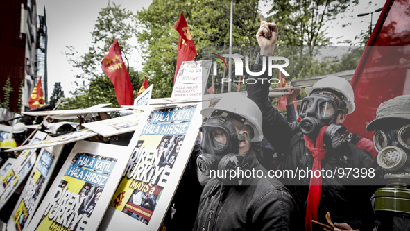 A Riot police officer leads a detained leftist demonstrator during clashes in downtown Istanbul, Turkey, Thursday, May 1, 2014. Turkish poli...