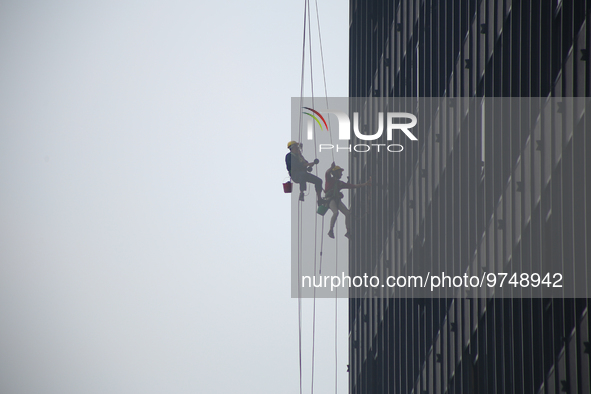 

Workers are hanging on by the rope as they clean the windows of a high-lying building in the Nepali capital, Kathmandu, on March 15th, 202...