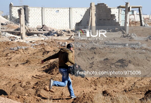 (151224) -- DAMASCUS, Dec. 24, 2015 () -- A Syrian cameraman runs in ravaged area in the rebel-held suburb of Daraya, west of Damascus, capi...