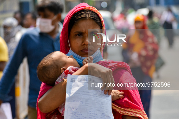 A mother carries her child with a prescription in hand , as seen at a hospital in Kolkata , India , on 16 March 2023 . Cases of respiratory...