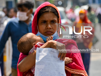 A mother carries her child with a prescription in hand , as seen at a hospital in Kolkata , India , on 16 March 2023 . Cases of respiratory...