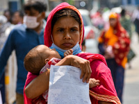 A mother carries her child with a prescription in hand , as seen at a hospital in Kolkata , India , on 16 March 2023 . Cases of respiratory...