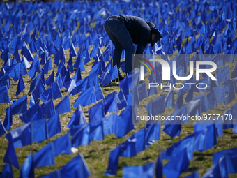 A man places flags at a visual exhibit organized by the Fight Colorectal Cancer organization on the National Mall in Washington, D.C. on Mar...