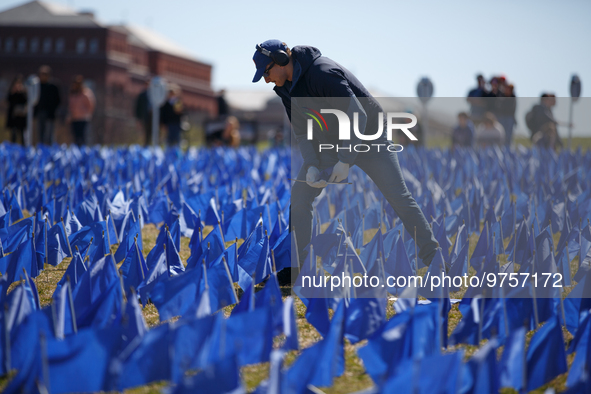 A man places flags at a visual exhibit organized by the Fight Colorectal Cancer organization on the National Mall in Washington, D.C. on Mar...