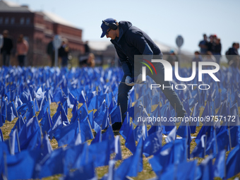 A man places flags at a visual exhibit organized by the Fight Colorectal Cancer organization on the National Mall in Washington, D.C. on Mar...