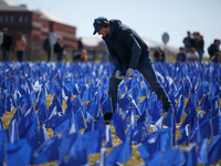 A man places flags at a visual exhibit organized by the Fight Colorectal Cancer organization on the National Mall in Washington, D.C. on Mar...