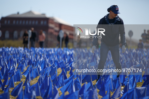 A man places flags at a visual exhibit organized by the Fight Colorectal Cancer organization on the National Mall in Washington, D.C. on Mar...