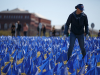 A man places flags at a visual exhibit organized by the Fight Colorectal Cancer organization on the National Mall in Washington, D.C. on Mar...