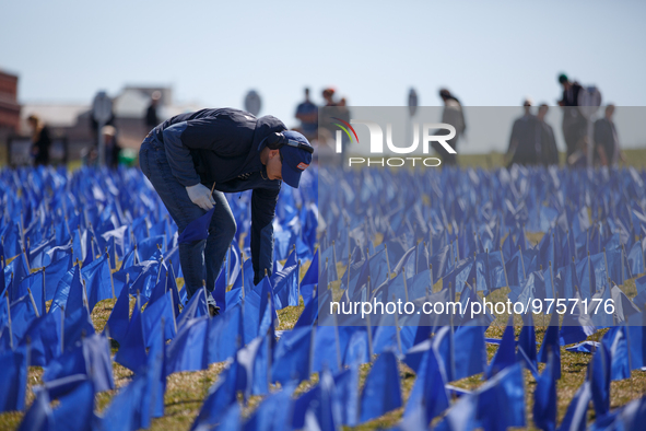 A man places flags at a visual exhibit organized by the Fight Colorectal Cancer organization on the National Mall in Washington, D.C. on Mar...