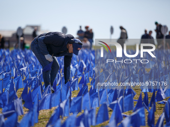 A man places flags at a visual exhibit organized by the Fight Colorectal Cancer organization on the National Mall in Washington, D.C. on Mar...