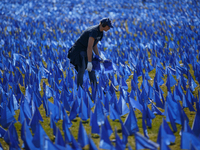 A man places flags at a visual exhibit organized by the Fight Colorectal Cancer organization on the National Mall in Washington, D.C. on Mar...