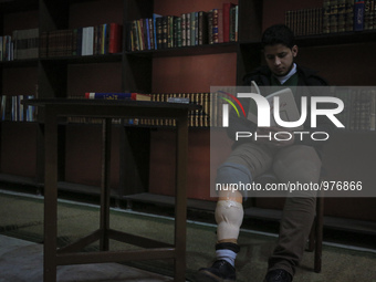 Nur reads a book in the hair Nizar Qabbani paper in the cultural center in the city of Aleppo on December 29,2015 .Nour lost his leg followi...
