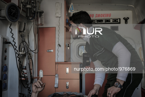 Nour, a 18-year-old Syrian man, helps a wounded man in a hospital, in a rebel-controlled area of Aleppo, on December 29, 2015. Nour lost his...