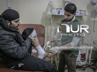 Nour, a 18-year-old Syrian man, helps a wounded man in a hospital, in a rebel-controlled area of Aleppo, on December 29, 2015. Nour lost his...