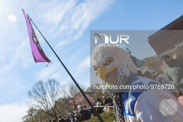 A demonstrator wearing a mask resembling a bald eagle holds a flag bearing a peace symbol during an anti-war protest in Washington, D.C. on...