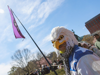 A demonstrator wearing a mask resembling a bald eagle holds a flag bearing a peace symbol during an anti-war protest in Washington, D.C. on...