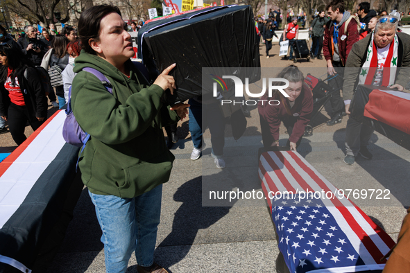 Demonstrators place symbolic body caskets on the ground in front of the White House during an anti-war protest in Washington, D.C. on March...