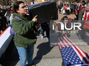 Demonstrators place symbolic body caskets on the ground in front of the White House during an anti-war protest in Washington, D.C. on March...