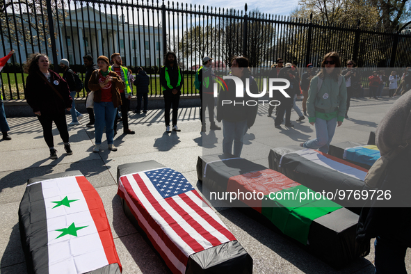 Demonstrators place symbolic body caskets on the ground in front of the White House during an anti-war protest in Washington, D.C. on March...