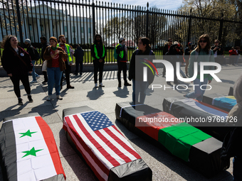 Demonstrators place symbolic body caskets on the ground in front of the White House during an anti-war protest in Washington, D.C. on March...