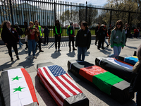 Demonstrators place symbolic body caskets on the ground in front of the White House during an anti-war protest in Washington, D.C. on March...