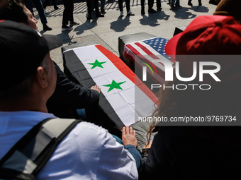 Demonstrators place symbolic body caskets on the ground in front of the White House during an anti-war protest in Washington, D.C. on March...