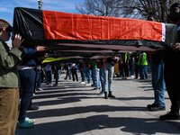 Demonstrators carry symbolic body caskets after placing them on the ground in front of the White House during an anti-war protest in Washing...