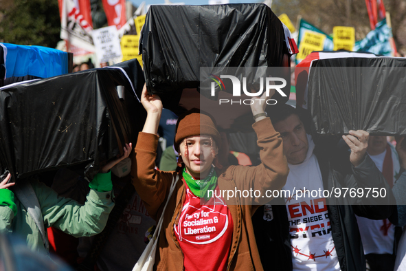 Demonstrators carry symbolic body caskets before placing them on the ground in front of the White House during an anti-war protest in Washin...