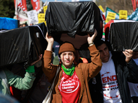 Demonstrators carry symbolic body caskets before placing them on the ground in front of the White House during an anti-war protest in Washin...