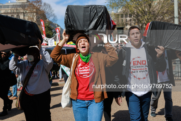 Demonstrators carry symbolic body caskets before placing them on the ground in front of the White House during an anti-war protest in Washin...