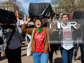 Demonstrators carry symbolic body caskets before placing them on the ground in front of the White House during an anti-war protest in Washin...