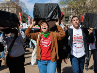 Demonstrators carry symbolic body caskets before placing them on the ground in front of the White House during an anti-war protest in Washin...