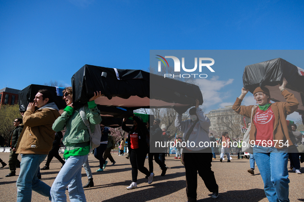 Demonstrators carry symbolic body caskets before placing them on the ground in front of the White House during an anti-war protest in Washin...