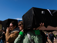 Demonstrators carry symbolic body caskets before placing them on the ground in front of the White House during an anti-war protest in Washin...