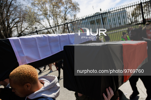 Demonstrators carry symbolic body caskets after placing them on the ground in front of the White House during an anti-war protest in Washing...