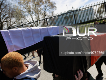 Demonstrators carry symbolic body caskets after placing them on the ground in front of the White House during an anti-war protest in Washing...