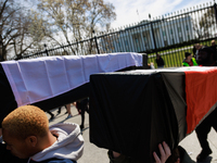 Demonstrators carry symbolic body caskets after placing them on the ground in front of the White House during an anti-war protest in Washing...